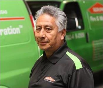 Male SERVPRO Technician with equipment as background