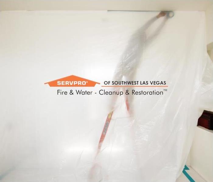 A crew member setting up a water containment in a home to restore copious amounts of water damage.