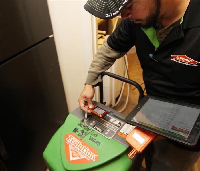 A SERVPRO Technician using equipment for restoring water damage